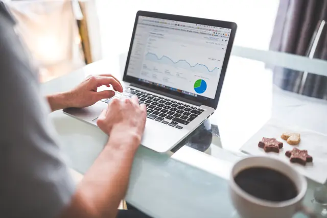 Une personne analyse des graphiques sur un ordinateur portable