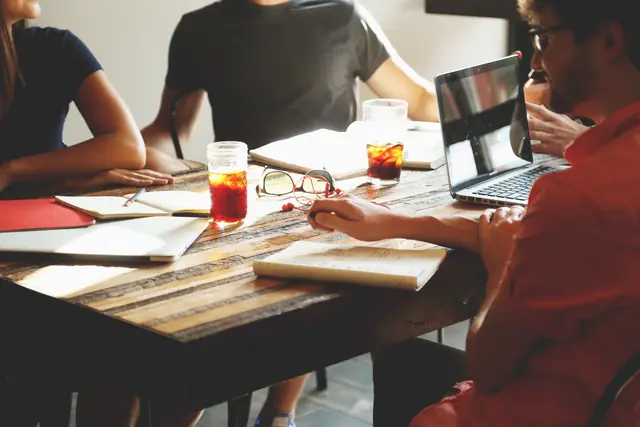 A team around a table with laptops and notebooks during a planning session